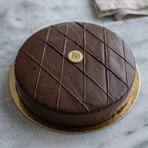 Succès Maison Bettant, entremet au chocolat, glaçage brillant strié en losanges, posé sur un marbre